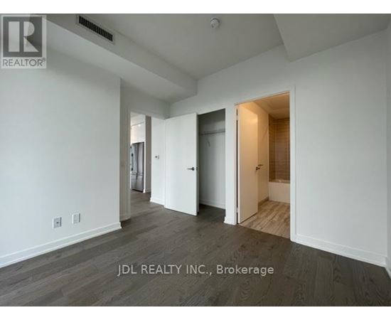 A spacious room with a doorway leading to another room.