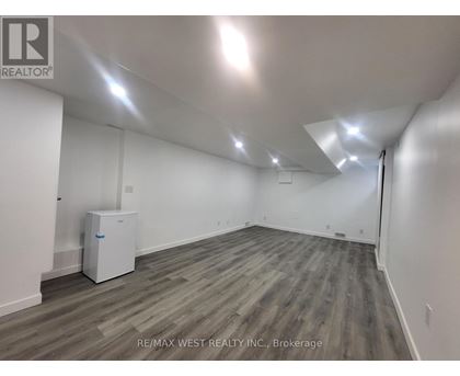 A spacious room with a wood floor and white walls.