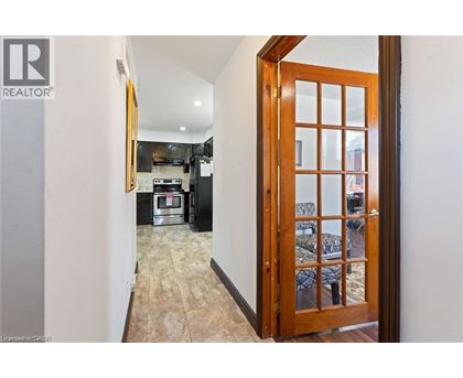 A hallway with a wooden door leading to a bedroom.