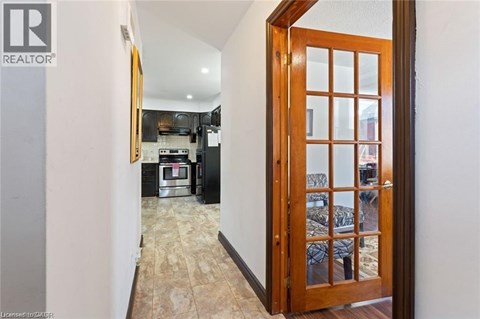 A hallway with a wooden door leading to a bedroom.