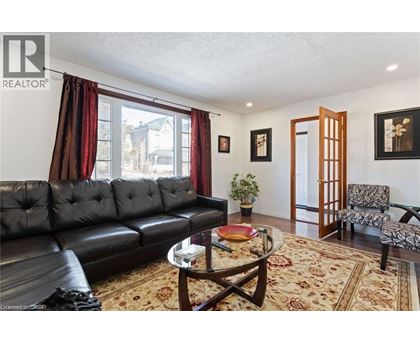 A living room with a black leather couch and a coffee table.