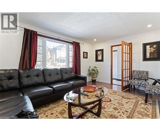 A living room with a black leather couch and a coffee table.