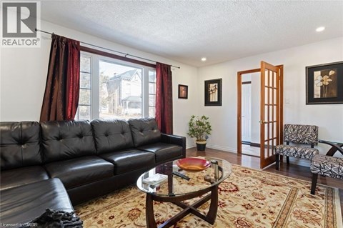 A living room with a black leather couch and a coffee table.