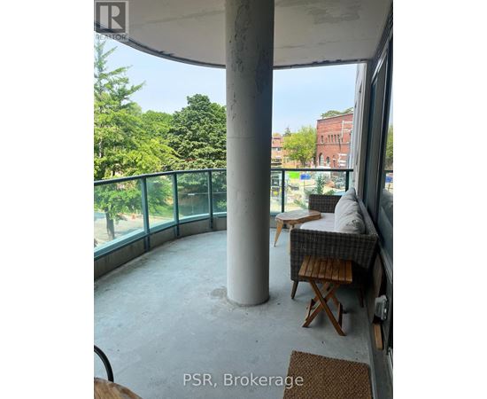 A balcony with a table and chairs overlooking a green area.
