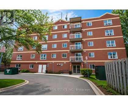 A red brick apartment building with a sign that says Valery Real Estate Inc., Brokerage.