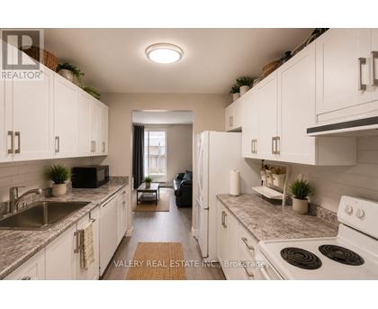 A kitchen with white cabinets and a refrigerator.