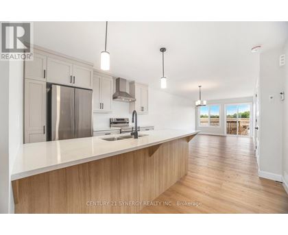 A modern kitchen with wooden cabinets and a stainless steel refrigerator.