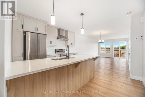 A modern kitchen with wooden cabinets and a stainless steel refrigerator.