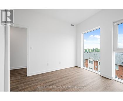 A white room with a window overlooking a building.