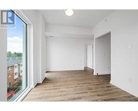 A white room with a wooden floor and a large window.