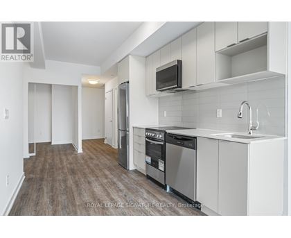 A kitchen with white cabinets and a wooden floor.