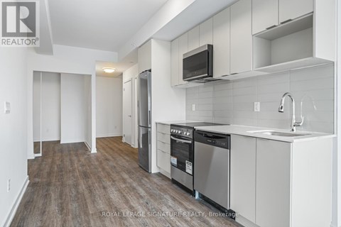 A kitchen with white cabinets and a wooden floor.