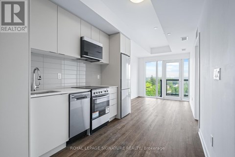 A modern kitchen with white cabinets and stainless steel appliances.