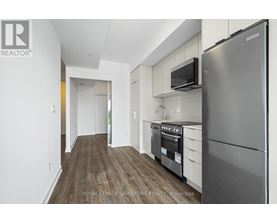 A modern kitchen with a stainless steel refrigerator and microwave.