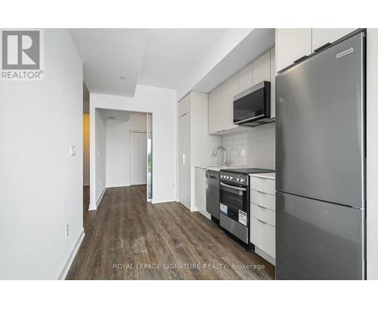 A modern kitchen with a stainless steel refrigerator and microwave.