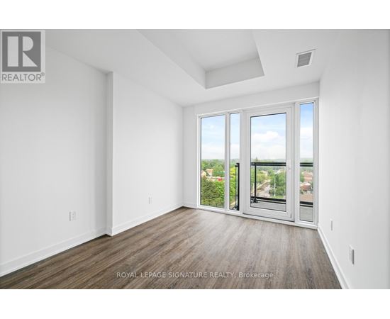 A white room with a sliding glass door leading to a balcony.