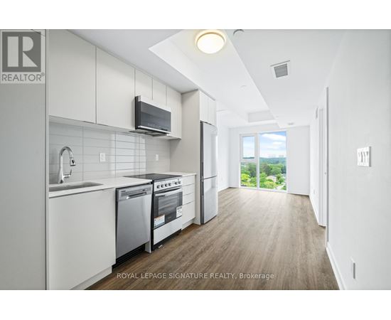 A modern kitchen with white cabinets and stainless steel appliances.