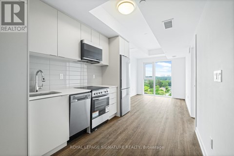 A modern kitchen with white cabinets and stainless steel appliances.