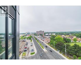 A view from a window looking out at a busy highway and buildings.