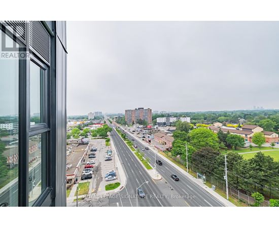 A view from a window looking out at a busy highway and buildings.