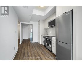 A kitchen with a refrigerator, oven, and microwave.