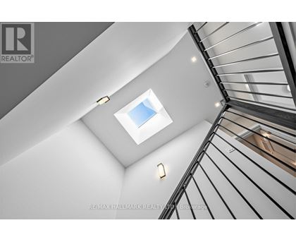 A skylight in a white ceiling with a black metal railing.