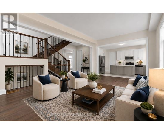 A modern living room with a staircase and a kitchen in the background.