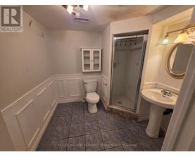 A bathroom with a toilet, sink, and shower.