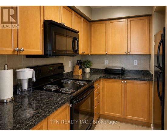 A kitchen with wooden cabinets and a black countertop.