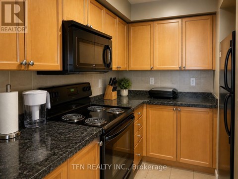 A kitchen with wooden cabinets and a black countertop.