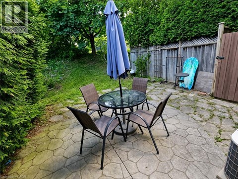 A patio with a table and chairs and an umbrella.
