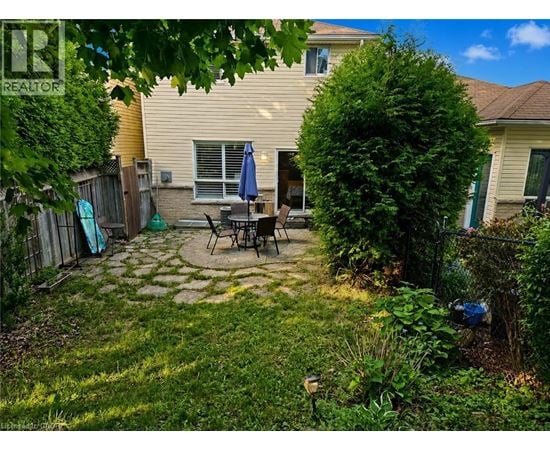 A backyard with a patio and a fence.