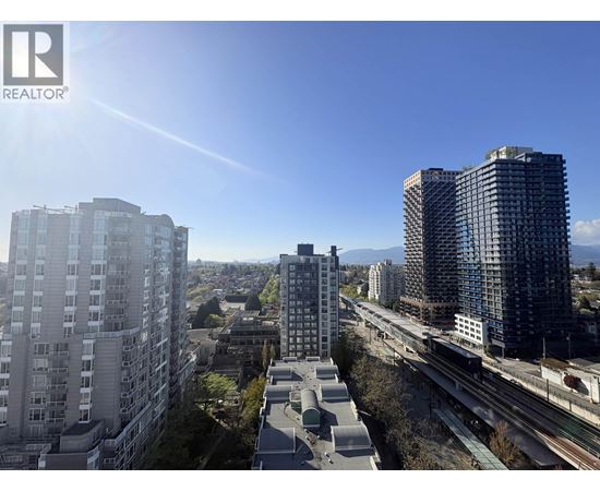 A cityscape with buildings and a train track.