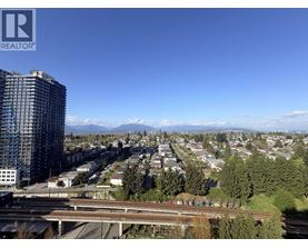 A cityscape with a tall building on the left and a highway in the foreground.