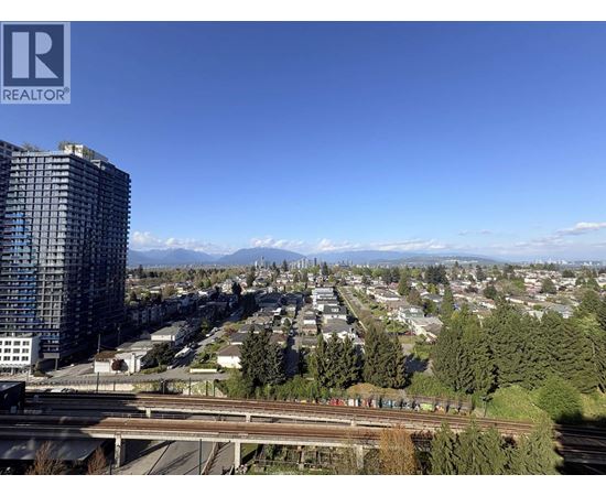 A cityscape with a tall building on the left and a highway in the foreground.