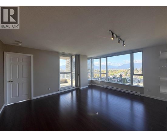 A spacious room with a view of the mountains outside the window.