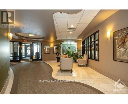 A hallway with a carpeted floor and a painting on the wall.