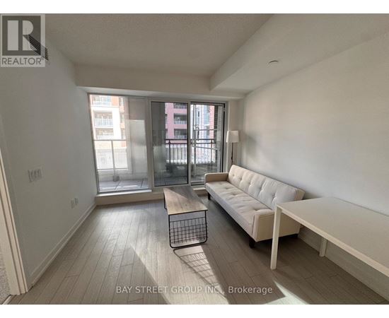 A living room with a white couch and a wooden floor.