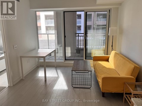 A living room with a white couch and a wooden floor.