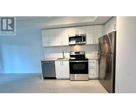 A kitchen with white cabinets and stainless steel appliances is on the market with Bay Street Group Inc.