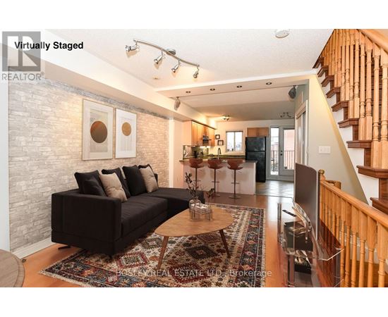 A living room with a couch, a coffee table, and a staircase.
