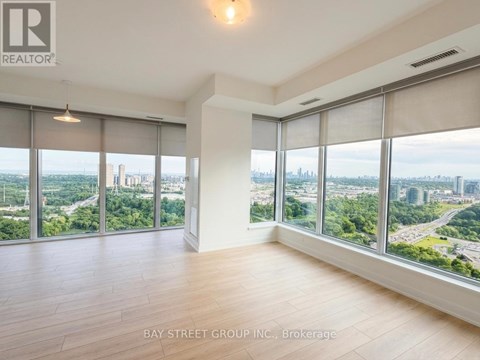 A spacious room with large windows overlooking a cityscape.