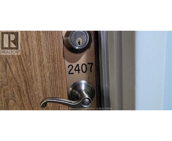 A door handle with a lock and a number 2407 on the door.