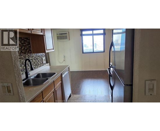 A kitchen with a sink and a refrigerator.