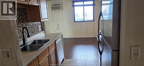A kitchen with a sink and a refrigerator.