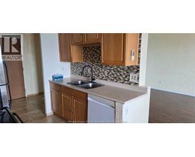 A kitchen with wooden cabinets and a tiled backsplash.