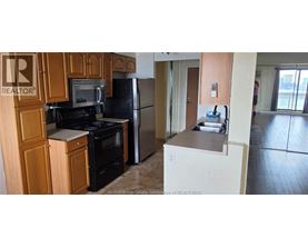 A kitchen with wooden cabinets and black appliances.