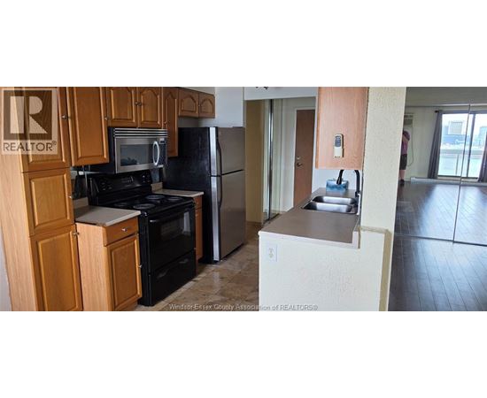 A kitchen with wooden cabinets and black appliances.