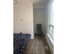 A bedroom with a bed and a chair.