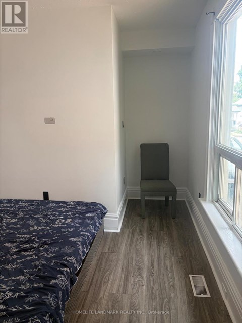 A bedroom with a bed and a chair.